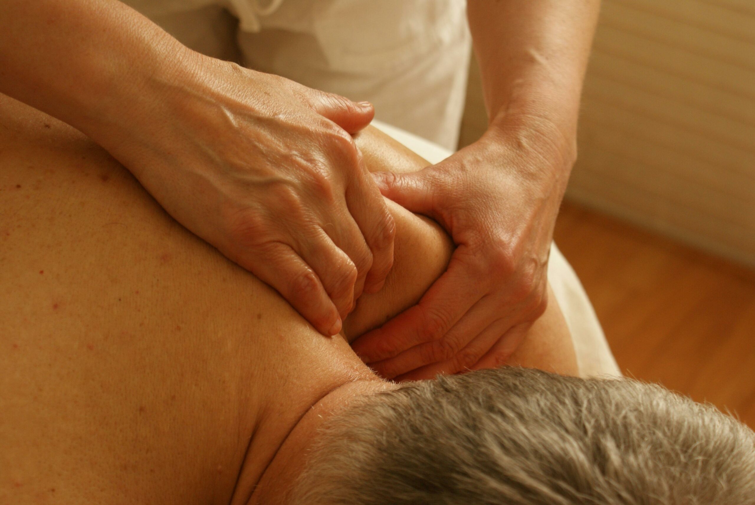 Home Close-up of a therapist giving a relaxing shoulder massage, enhancing wellness and stress relief.