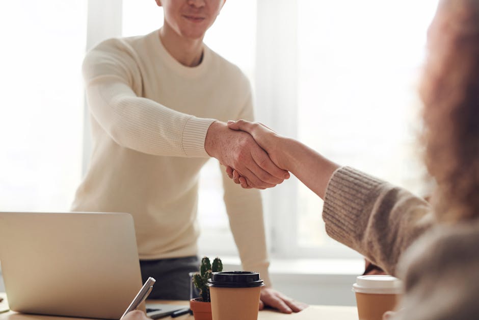 pexels photo 3184465 3184465 1 Close-up of professionals shaking hands over coffee in a modern office.